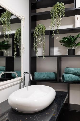 a bathroom with a white sink and a mirror at Ultra central apartment in Baia Mare