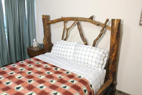 uma cama com uma cabeceira em madeira e uma almofada em Utah's Great Outdoors. 2 Bd/1 Ba + kitchen em Salt Lake City