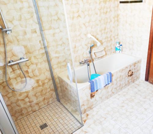 a bathroom with a shower with a tub and a sink at Appartamento vacanze da Paola in Roccabruna