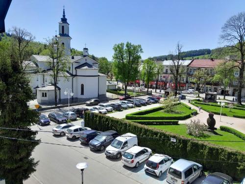 un estacionamiento con autos estacionados frente a una iglesia en Willa Dniestrzanka en Krynica Zdrój