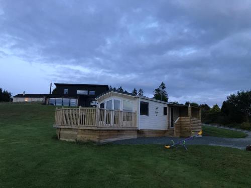 a house with a porch and a deck at STORR (caravan skye holidays) in Portree