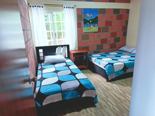 a bedroom with two beds and a window at Hospedaje casa campestre in Roldanillo