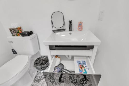 a bathroom with a sink and a toilet and a mirror at Luxe 1 BR apt EWR Prudential Center in Elizabeth