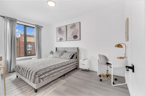 a bedroom with a bed and a desk and a window at Luxe 1 BR apt EWR Prudential Center in Elizabeth