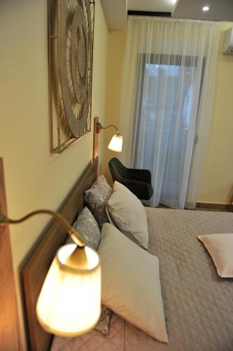a bedroom with a bed with a lamp and a window at Studio apartmani Anika in Vrdnik