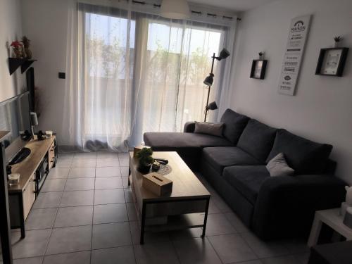 ein Wohnzimmer mit einem Sofa und einem Tisch in der Unterkunft Appartement entier in Aime La Plagne