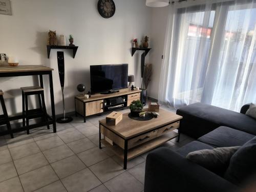 un salon avec un canapé et une télévision dans l'établissement Appartement entier, à Aime La Plagne