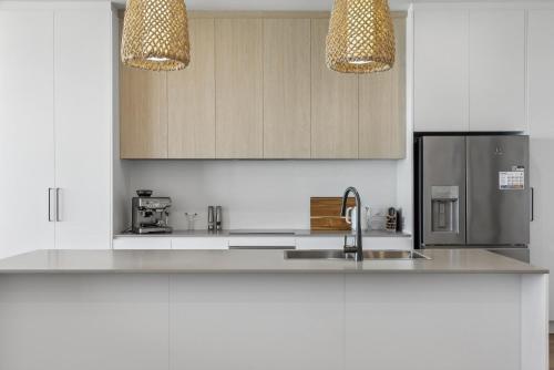 a kitchen with a sink and a refrigerator at Seamist On Seagull WiFi in Hayborough