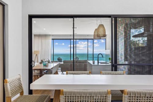 a kitchen and dining room with a view of the ocean at Seamist On Seagull WiFi in Hayborough