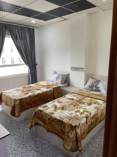 ドホークにあるZirka Apartments Duhokのベッドルーム1室(ベッド2台、窓付)