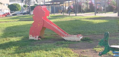 a statue of a dog on a slide in a park at Ático carrizal in Carrizal