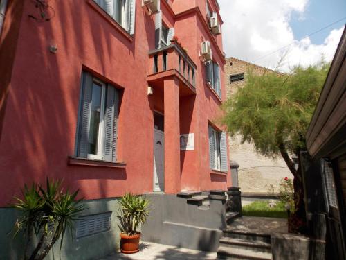 a red building with plants in front of it at Guest House Miss Depolo in Belgrade