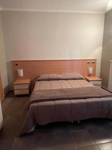 um quarto com uma cama grande e duas mesas de cabeceira em Appartamento in centro Paese em Frabosa Soprana