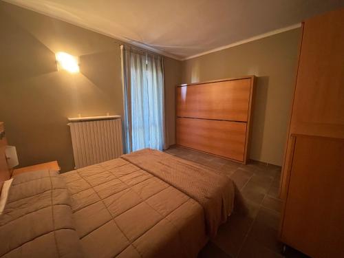 um quarto com uma cama e uma cabeceira em madeira em Appartamento in centro Paese em Frabosa Soprana