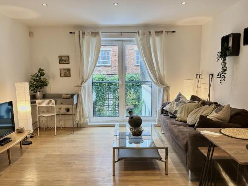 a living room with a couch and a table at Kings Cross City Apartment in London