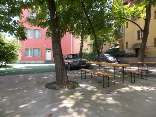 a park bench in front of a building with trees at Guest House Miss Depolo in Belgrade