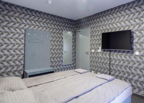 1 dormitorio con 1 cama y TV de pantalla plana en Bed and Breakfast 33, en Duisburg