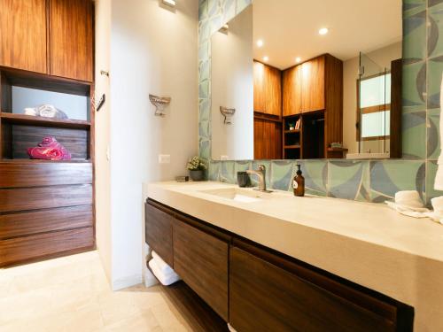 uma casa de banho com um lavatório e um espelho grande em Carmensita em San José del Cabo