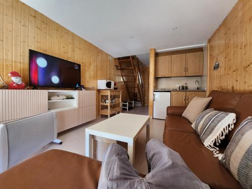 ein Wohnzimmer mit einem Sofa, einem Tisch und einem TV in der Unterkunft DÚPLEX CON VISTAS ZONA MEDIA in Sierra Nevada