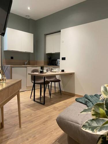 une cuisine avec une table et des chaises dans une pièce dans l'établissement Moderne et calme en hyper centre, à Aix-les-Bains