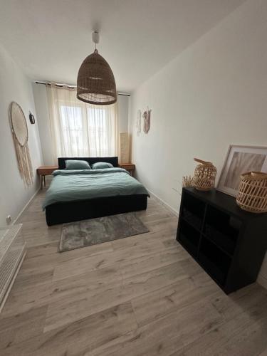 1 dormitorio con cama verde y ventana grande en Apartament Kiekrz, en Baranowo