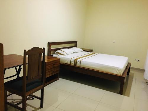 a bedroom with a bed and a desk and a chair at Constança Retreat in Mindelo