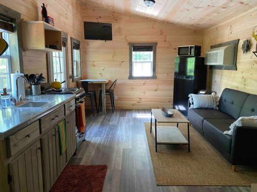 a kitchen and living room in a log cabin at Red River Gorge Couples and Climbing getaway in Prime Location! in Campton