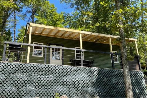 a green house with a pergola on top of it at Red River Gorge Couples and Climbing getaway in Prime Location! in Campton