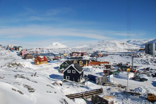 a town covered in snow with mountains in the background at Vandrehuset 2 og 3 in Nuuk