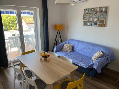 a living room with a blue couch and a table at Apartment Vitezic in Punat