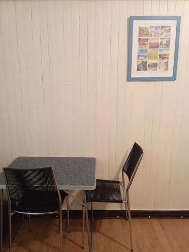 une table et des chaises dans une pièce avec une photo sur le mur dans l'établissement Chambres d'hôtes du Péras, à Saint-Jean-du-Gard