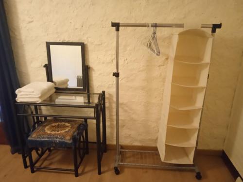 einen Waschtisch mit einem Tisch, einem Spiegel und einem Regal in der Unterkunft Chambres d'hôtes du Péras in Saint-Jean-du-Gard