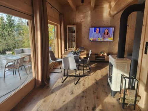 a living room with a stove and a tv on the wall at LITTLE KOIS VILLAGE in Dzianisz