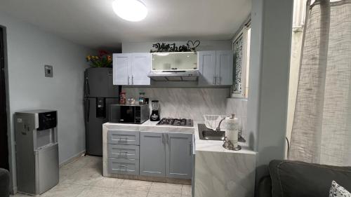 a small kitchen with a stove and a refrigerator at Private Penthouse / Penthouse Privado in Mexico City