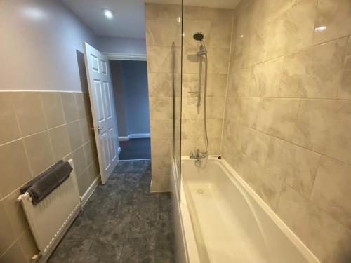 Spacious 2 bedroom flat london في لندن: حمام مع حوض استحمام ودش