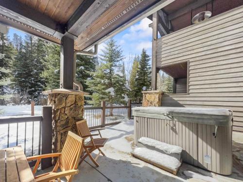a patio with a hot tub and two chairs at 35A Union Creek Townhomes West townhouse in Copper Mountain