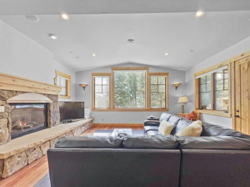 a living room with a black leather couch and a fireplace at 35A Union Creek Townhomes West townhouse in Copper Mountain