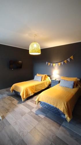 a bedroom with two beds and a chandelier at La Pascuala in Balneario Claromecó