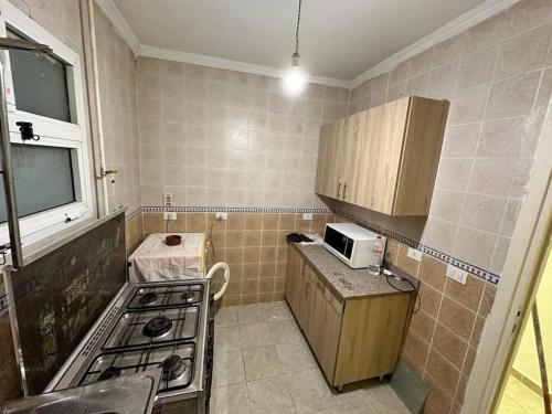 a small kitchen with a stove and a microwave at Flat in Madenty in Madinaty