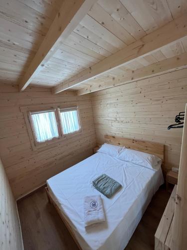 ein Schlafzimmer mit einem Bett in einer Holzhütte in der Unterkunft El Corralón de Altarejos 