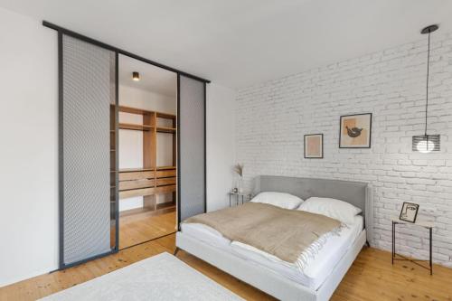 a bedroom with a white brick wall and a bed at AH Luxury Old Town in Bratislava