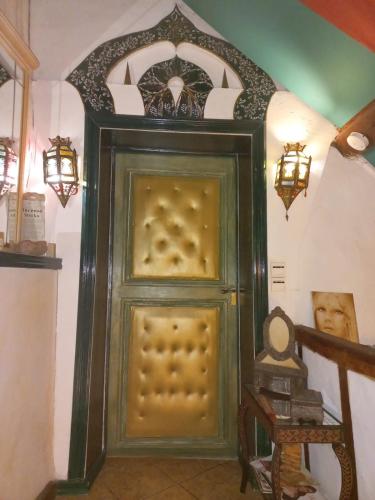 une grande porte verte sur un escalier avec des lumières dans l'établissement Location meublé de tourisme La Rose des Fables, à Château-Thierry