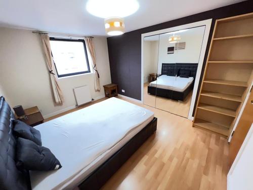 um quarto com uma cama grande e um espelho em Lovely Two-bed Apt em Aberdeen