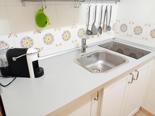a white kitchen with a sink and utensils at Appartamento con Terrazza Fronte Mare in Riccione