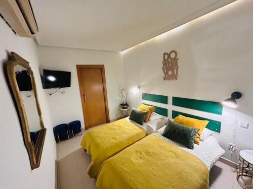 マドリードにあるManuel Becerra - Plaza de toros Ventas - ALQUILER TEMPORAL - HOSPITALESのベッドルーム1室(黄色いシーツを使用したベッド2台付)