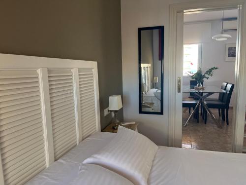 ein Schlafzimmer mit einem weißen Bett und ein Esszimmer in der Unterkunft Ático con vistas cerca del mar - Penthouse - parking - terraza in Torre del Mar
