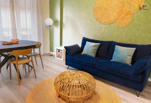 un salon avec un canapé bleu et une table dans l'établissement Chez la Clo' - joli 2 pièces, parking gratuit, accès direct tram 2 min à pied, à Strasbourg