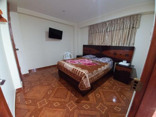 1 dormitorio con 1 cama y TV en KISWAR, en Huánuco