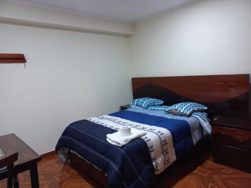 1 dormitorio con 1 cama con manta azul en KISWAR, en Huánuco