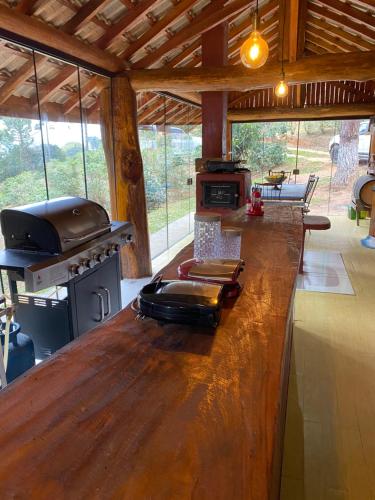 eine Küche mit einer Bar in einer Hütte mit einem Herd in der Unterkunft Cabana Fenix Sitio Nossa Terra in Joanópolis